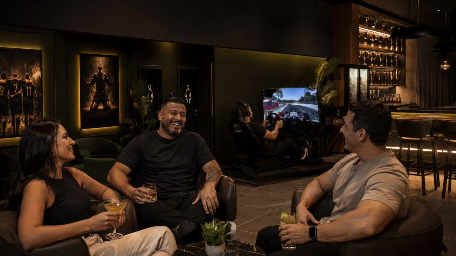 Grupo de amigos conversando no lounge, com o simulador de corrida ao fundo